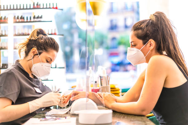 istock Manicure and pedicure salon with security measures and people with masks, performing a pedicure treatment. Reopening after the corod-19 pandemic. Coronavirus 1304843493