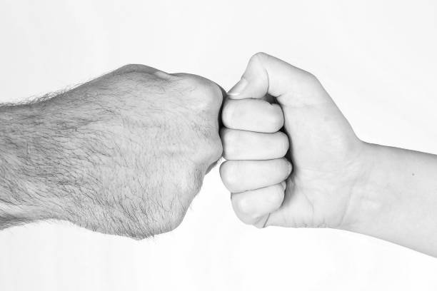 istock Man and woman striking fists 1304847320