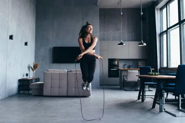 Sportsgirl with skipping rope at home