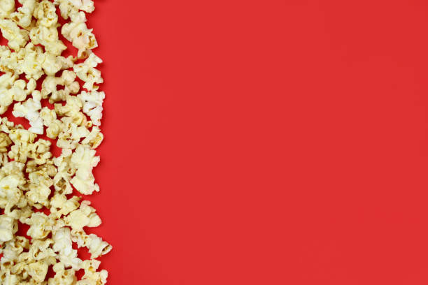 istock caramel popcorn on a red background top view. Copy space for text 1304848388