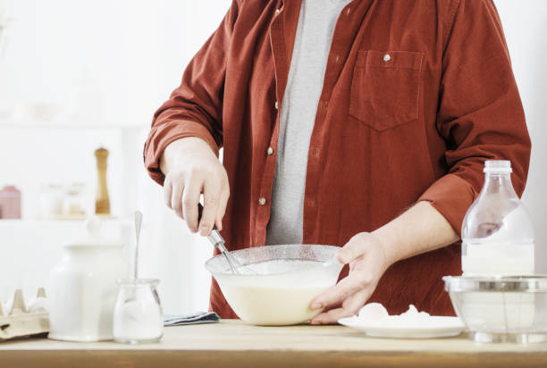 istock middle-aged man kneading pancake dough on white kitchen 1304849534