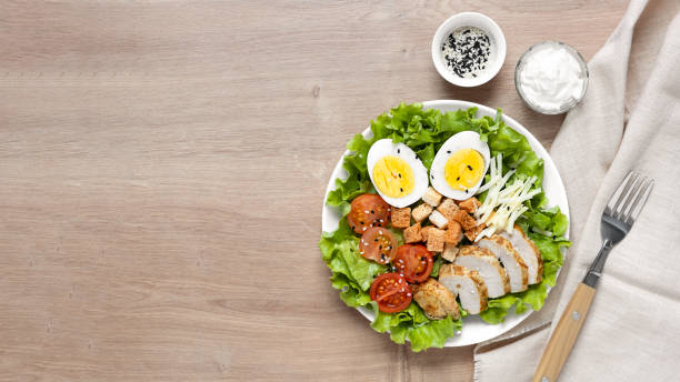 Caesar salad with fried chicken, fresh tomatoes, croutons, lettuce, parmesan cheese and eggs. Healthy eating