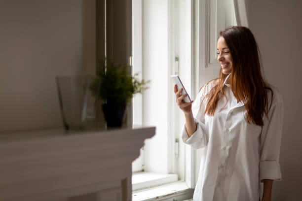 istock Relaxed woman at home reading a text message in her bedroom 1304851793
