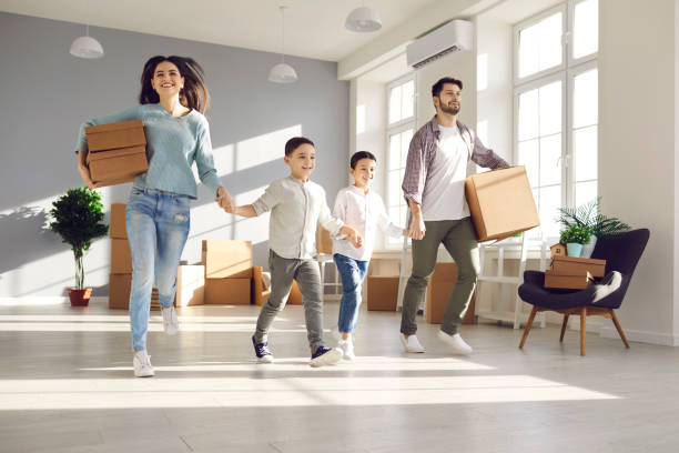 familia joven feliz con niños pequeños corriendo para explorar su nueva casa o apartamento - moving house physical activity real estate couple fotografías e imágenes de stock