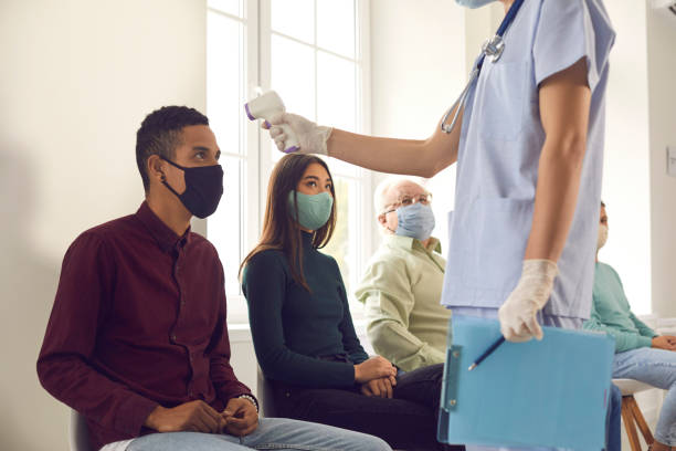 istock Medical worker measuring patient's body temperature using non-contact digital thermometer 1304852856