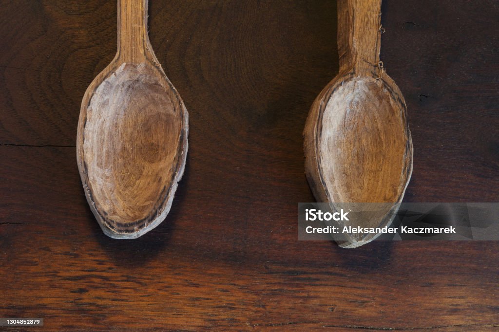 Two Wooden Spoons On A Wooden Table Close up of two wooden spoons on a dark wooden table. Top View. Art Stock Photo