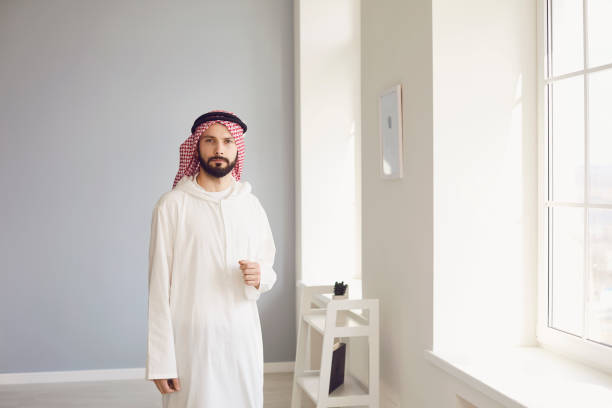 istock Attractive arab man standing in modern office 1304853479