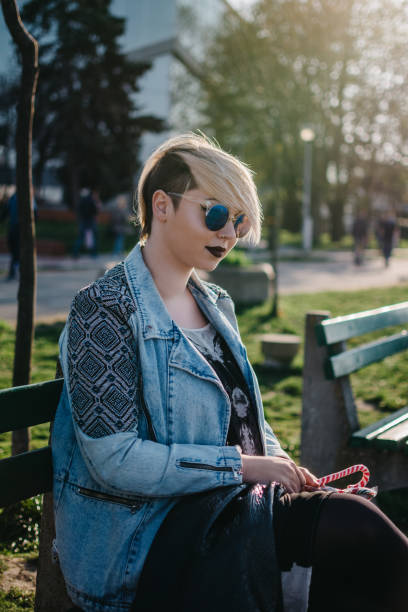 istock Young woman sitting in a park 1304854218