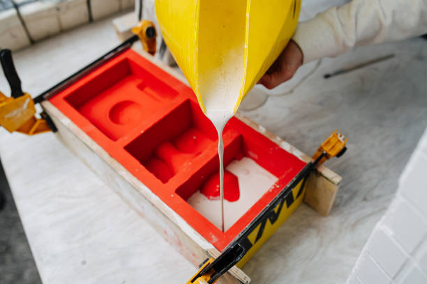Hands pouring gypsum plaster in open form for mold casting for making tableware.