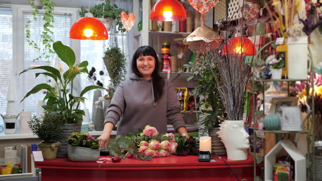 Portrait happy woman florist in flowers shop. Smiling business woman in own flower studio with bouquet. Small flower business concept.