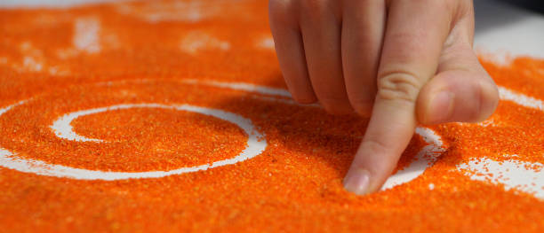 terapia de arena, la mano del niño se basa en la arena naranja - child sensory perception expressing negativity human hand fotografías e imágenes de stock