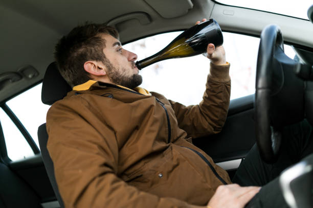 hombre bebiendo alcohol mientras conducía - drunk driving accident teenager fotografías e imágenes de stock