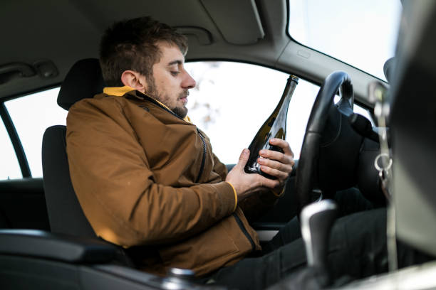 hombre bebiendo alcohol mientras conducía - drunk driving accident teenager fotografías e imágenes de stock