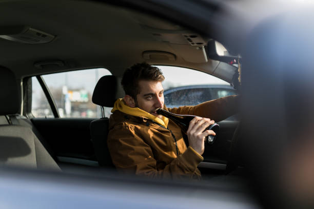 hombre bebiendo alcohol mientras conducía - drunk driving accident teenager fotografías e imágenes de stock