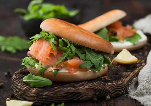 Organic healthy sandwiches with salmon and bagel, cream cheese and wild rocket and lemon and pepper.