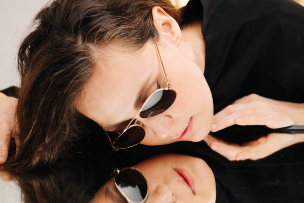 istock Beautiful middle aged woman in sunglasses lying on a highly reflective table 1304865479