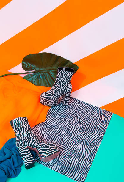 istock Stylish platform boots on bright striped yellow background. Tropical exotic minimal concept. Yellow and zebra print mixed. Still life fashion scene 1304869594