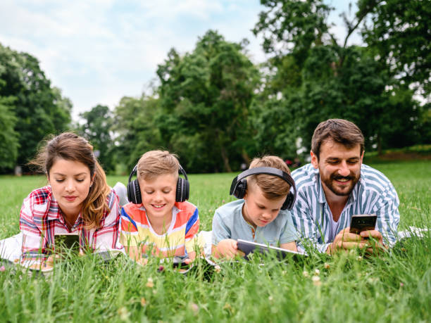 istock Family using mobile phones together in nature. 1304871996