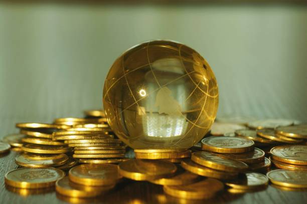 istock A small glass globe with coins on a colored background. 1304873160