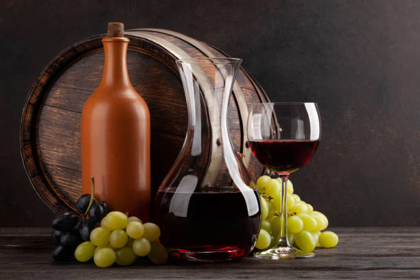 istock Wine bottle, decanter, glass and old wooden barrel 1304876301