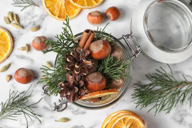 Aroma potpourri with different spices on white marble table, flat lay