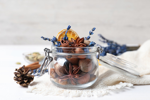 Aromatic potpourri in glass jar on white background