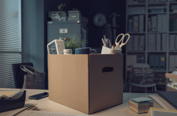 Office worker belongings in a cardboard box Office worker belongings in a carton box: job dismissal and crisis concept belongings stock pictures, royalty-free photos & images