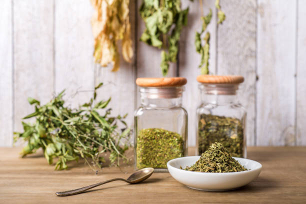 травяной чай и сушеные травы или лекарства в банках с ложкой - herb стоковые фото и изображения