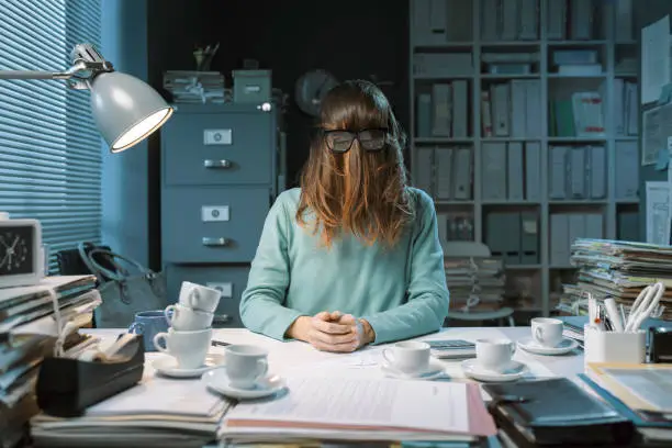 Insane office worker covering her face with hair and wearing glasses, workplace burnout concept