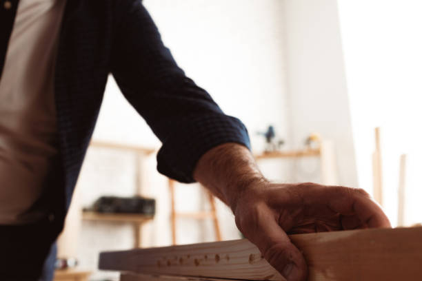 istock Male carpenter working with a wooden bar in a workshop 1304878704