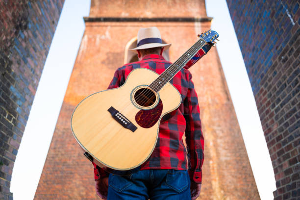 istock Man wandering in nature at sunset with guitar on his back 1304879053