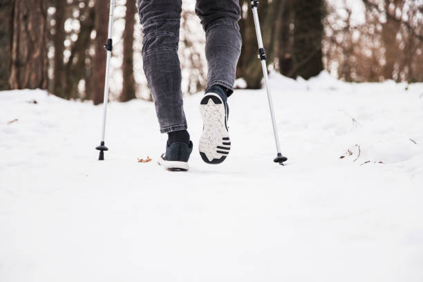 primo passo per camminare sulla neve con bastoncini da trekking - journey footpath exercising effort foto e immagini stock