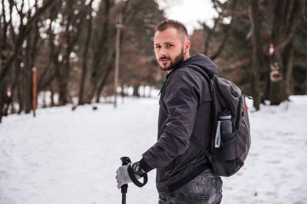 istock Fit man looking over his shoulder during hike on the snow 1304880546