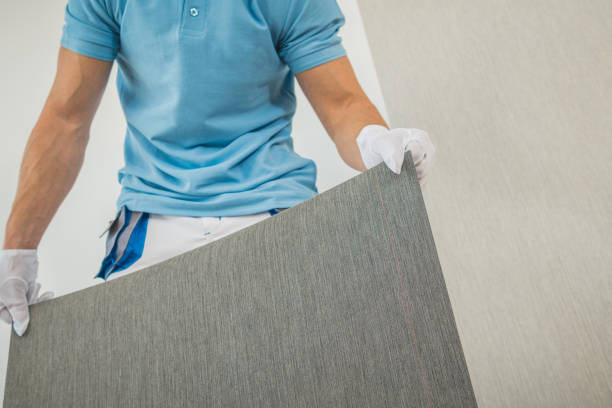 istock Men Preparing New Vinyl Wallpaper for Wallcover 1304883219