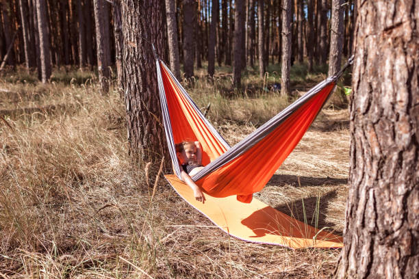 istock Girl having rest in hammock in wild forest during local vacation, unity with nature, digital detox 1304883259