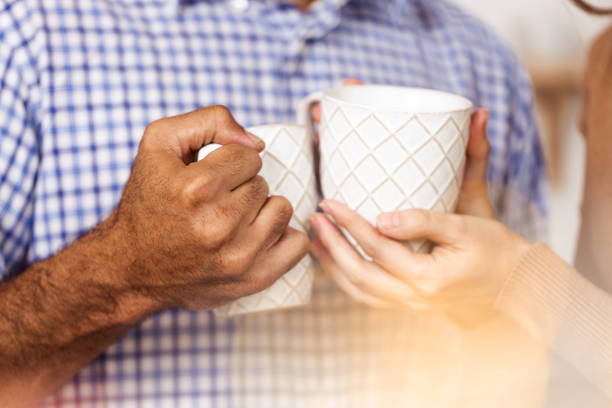 istock Hands of loving couple having hot drinks close up 1304883414