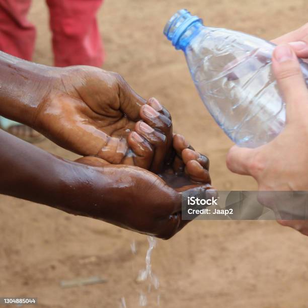 White Volunteer Teaching Locals In Cameroon How To Wash Hands Stock Photo - Download Image Now