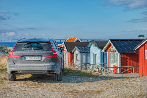 um carro volvo v60 d4 preto estacionado do lado de fora em um porto, ao lado da típica sommarstuga sueca (stuga) ou casas de veraneio nórdica à beira-mar - klagshamn - fotografias e filmes do acervo