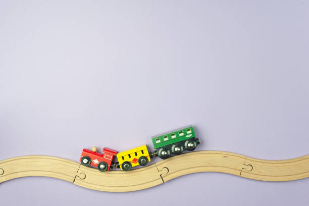 istock Toy railway and a small train on a purple background. Flat lay, Top view. Place for text 1304886224