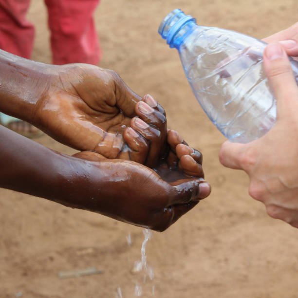 istock White volunteer teaching locals in Cameroon how to wash hands 1304887619