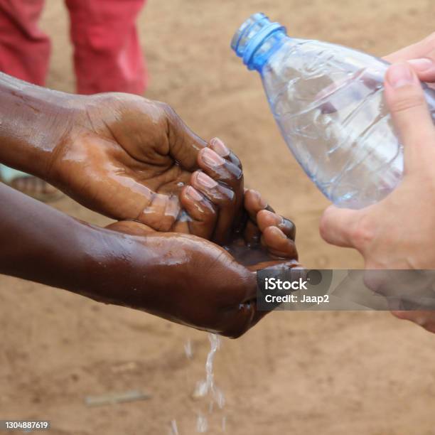 White Volunteer Teaching Locals In Cameroon How To Wash Hands Stock Photo - Download Image Now