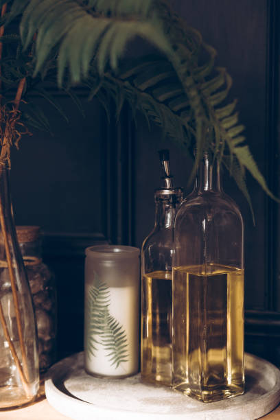 istock Glass bottles and decorative candle on a black background. Home kitchen decor. Home interior decor. 1304888432