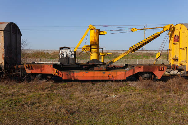 istock Old yellow cargo crane wagon on abandoned train tracks in the field 1304888661