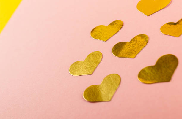 istock Shiny golden Heart shape stickers on pink background with copy space. 1304889028