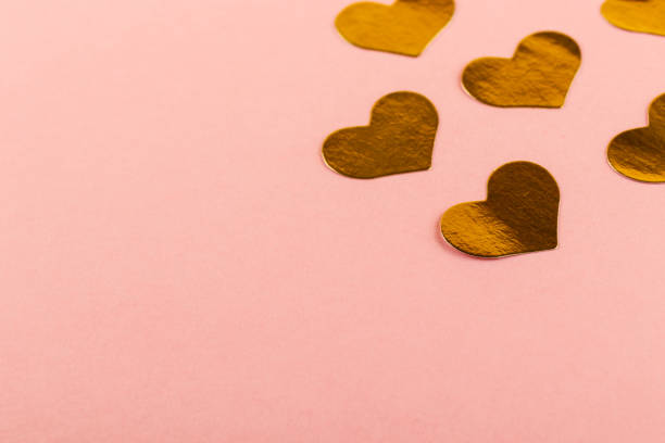 istock Shiny golden Heart shape stickers on pink background with copy space. 1304889038