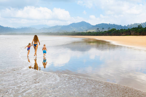 istock Happy family run by wide sand beach 1304889557