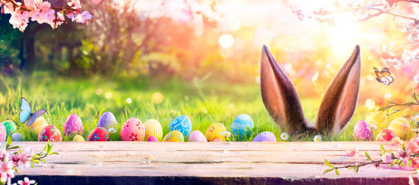istock Easter - Ears Bunny Behind Grass And Decorated Eggs In Flowery Field 1304891632