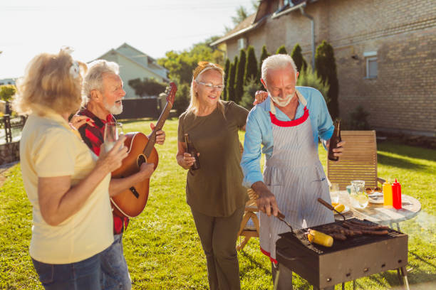 istock Elderly people playing the guitar and singing while having a backyard barbecue party 1304896215