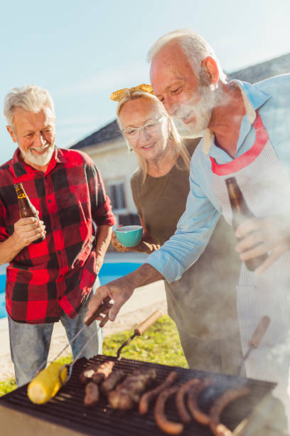 istock Elderly friends grilling meat in the backyard 1304896600