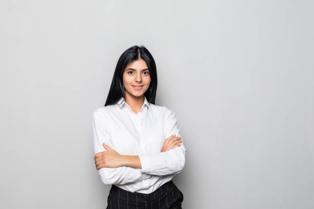 istock Smiling business woman with folded hands against white background. 1304898601